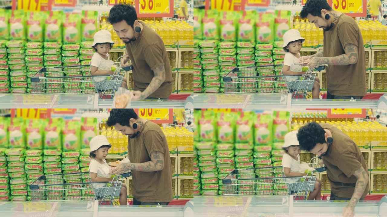 时髦的男人和他的儿子在当地超市的冷藏区买了一些冷冻食品。