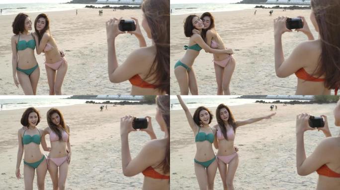 一群年轻女孩用单反相机时尚摄影在海滩上快乐假期摄影音乐派对拍照。慢动作。