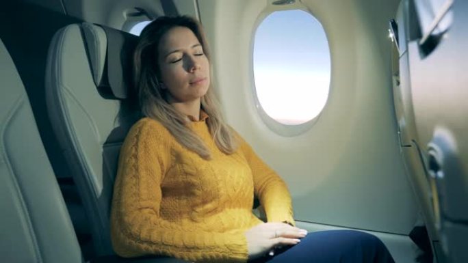 华丽的女人睡在飞机的机舱里