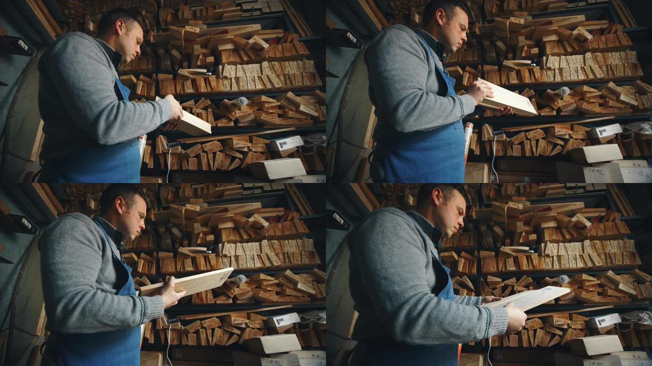 工匠制琴师的慢动作在车间中选择木材制作手工小提琴