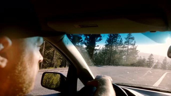 优胜美地大胡子男子驾驶汽车沿着林道拍摄的美丽特写镜头，聚焦侧镜慢动作。