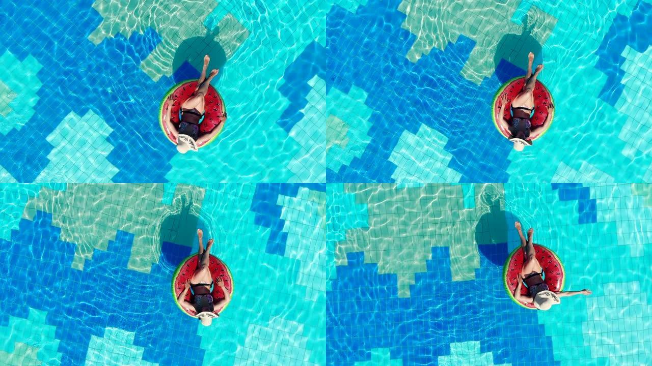 游泳圈中的一位女士正沿着游泳池漂浮。暑假概念。