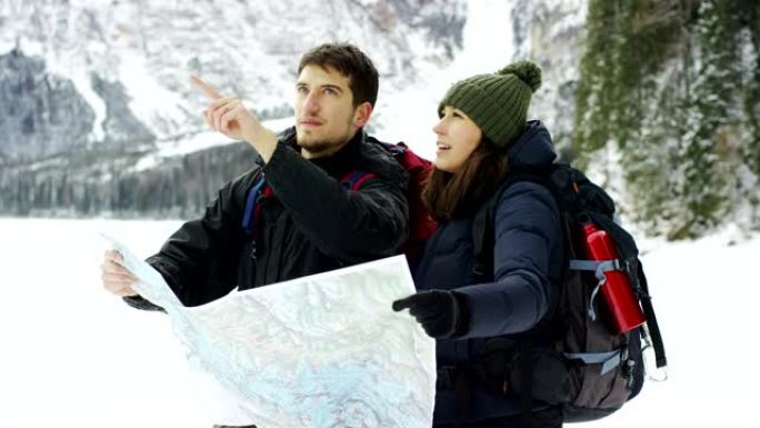 一对在山上度假的好夫妇看着地图，以免迷路并了解地图的位置。