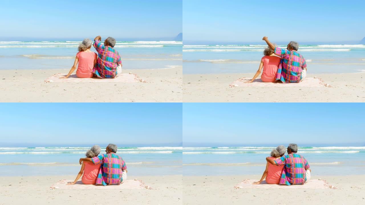 活跃的高级非洲裔美国夫妇在4k海滩的阳光下在毯子上放松的后视图