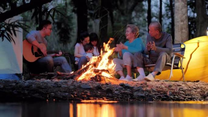 快乐的亚洲大家庭享受在森林篝火附近的夜晚露营。家庭，生活方式，人，多代，老人，假期，关系，假期，退休