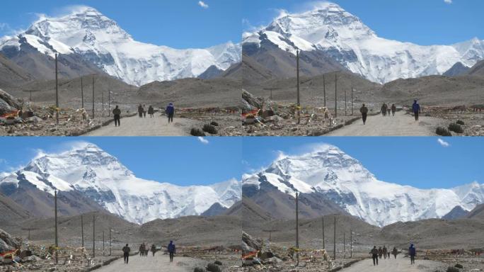 慢动作: 旅行者向风吹拂的珠穆朗玛峰徒步旅行的电影镜头。