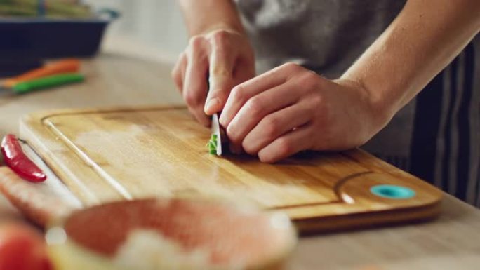 一名男子用锋利的菜刀切碎葱的特写镜头。在现代厨房准备健康的有机沙拉餐。天然清洁饮食和健康的生活理念。