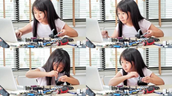 女孩在家中在计算机上进行构建和编程，并将其作为学校科学项目来构建机器人手臂。她对他的r work.e