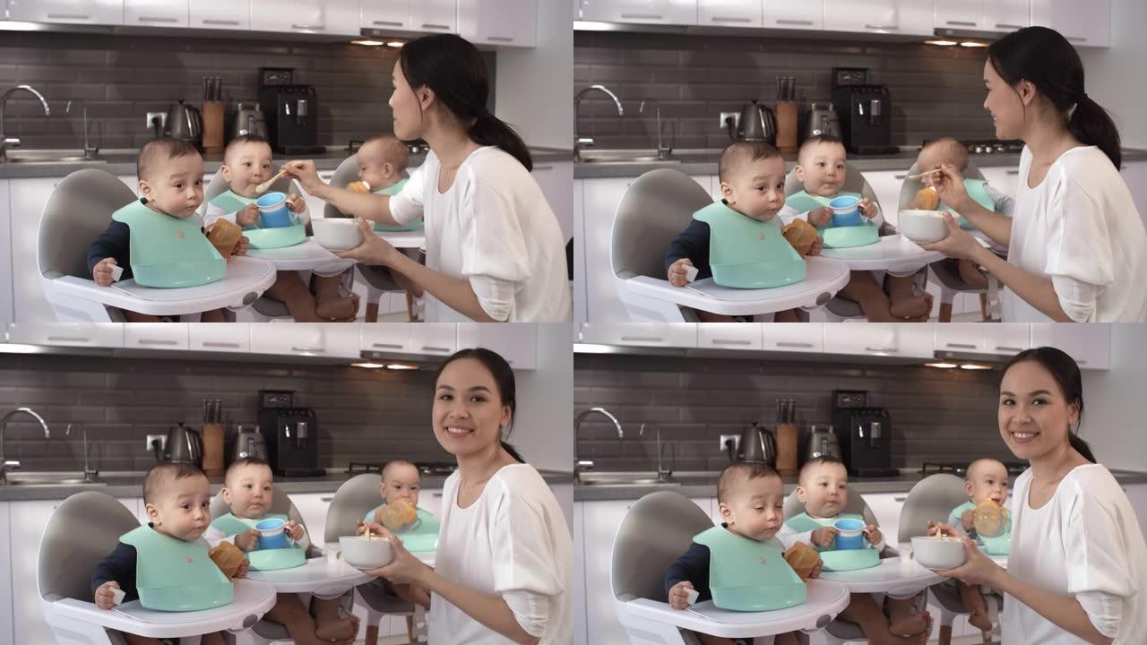 亚洲妈妈在厨房里和三胞胎在喂食时摆姿势