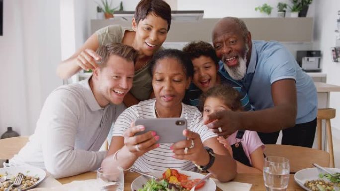 多代混血家庭在家里一起吃饭时摆姿势自拍