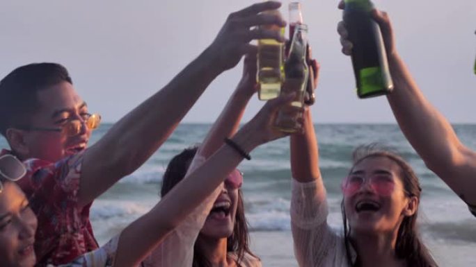 一群朋友在海滩上玩得开心，喝酒。慢动作。假期概念。假期-iStock