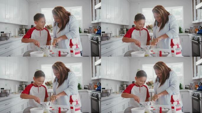 十几岁的西班牙裔男孩和他的祖母在厨房里做蛋糕，混合蛋糕混合物，特写