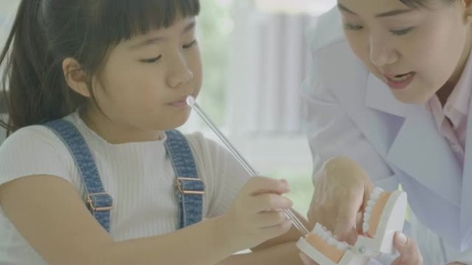 小亚洲学生女孩在解剖学课上学习下颌模型的人体骨骼。科学与教育。