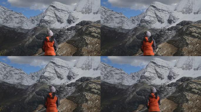 4k; 站在山顶的女人的后视图。