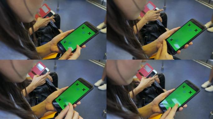女人在火车上使用带有绿屏的智能手机