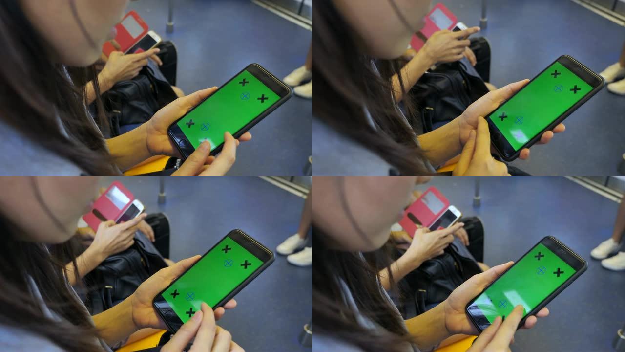 女人在火车上使用带有绿屏的智能手机
