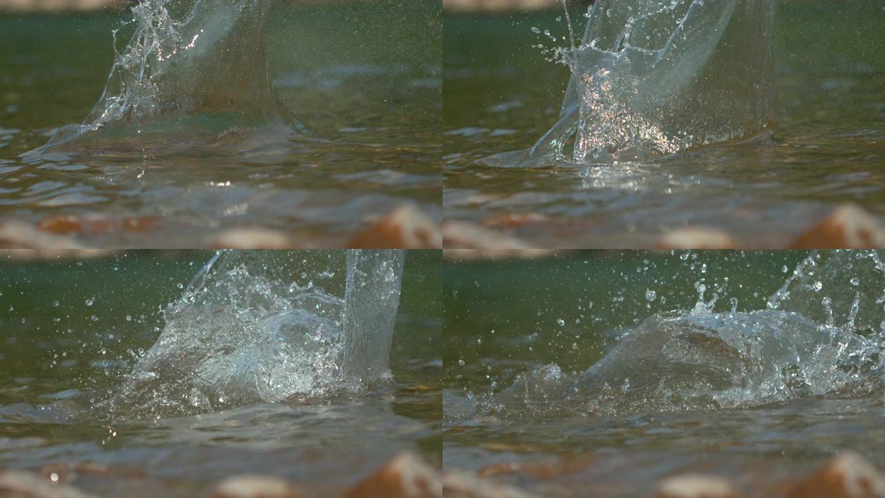 宏观: 卵石掉入河中后，玻璃状的水滴在空中飞舞。