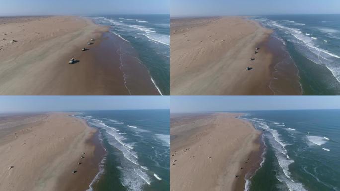 纳米比亚纳米布沙漠骨架海岸海滩上行驶的4x4车辆车队的4k空中缩小视图