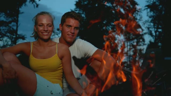 特写: 在寒冷的夜晚，快乐的高加索夫妇坐在篝火旁。
