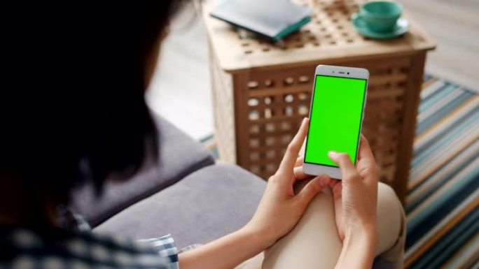 学生在家中使用带有绿色模拟屏幕滑动的智能手机