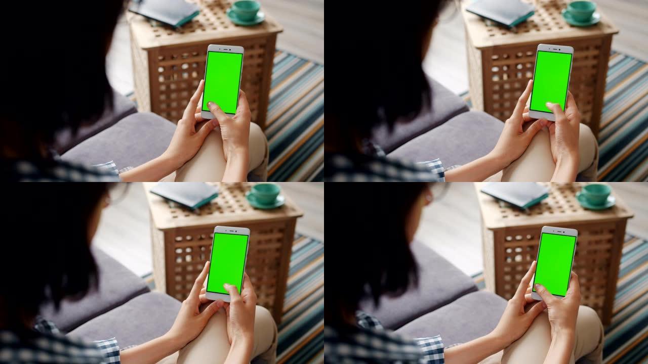 学生在家中使用带有绿色模拟屏幕滑动的智能手机