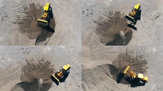拖拉机在采石场移动一堆沙子。