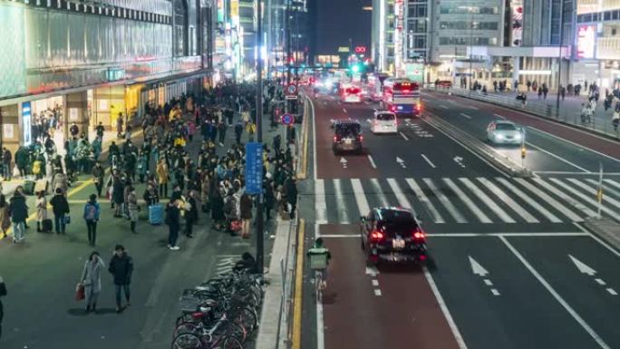 人群的时间流逝不确定的人走在街上与汽车交通在日本新宿东京市的夜晚