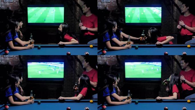 多样化的亚洲朋友在sporstbar观看电视。他们的球队进球并获胜。兴奋的朋友在酒吧喝啤酒时观看足球
