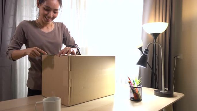 亚洲女性在家网上购物打开盒子