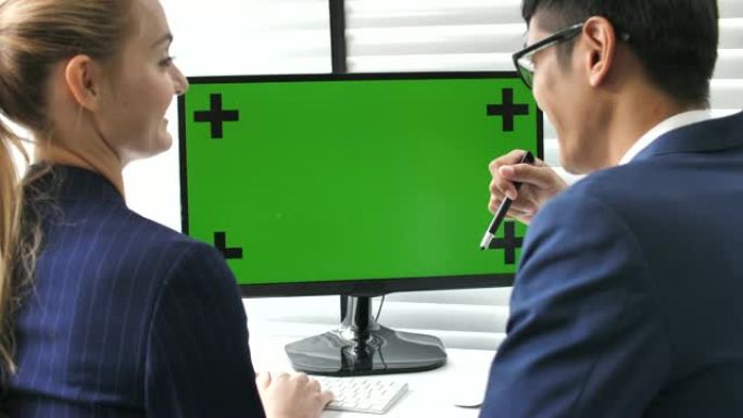 两名商务人士在办公室使用电脑绿屏