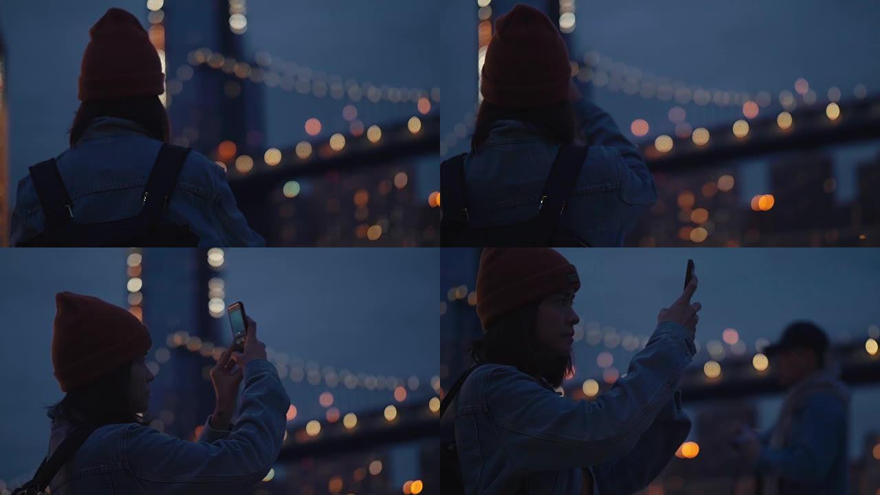 年轻的亚洲女性在河边用智能手机拍摄桥梁的照片