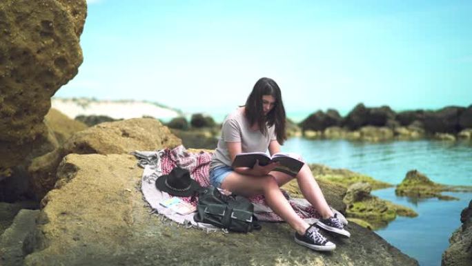 坐在沙滩上看书的女孩