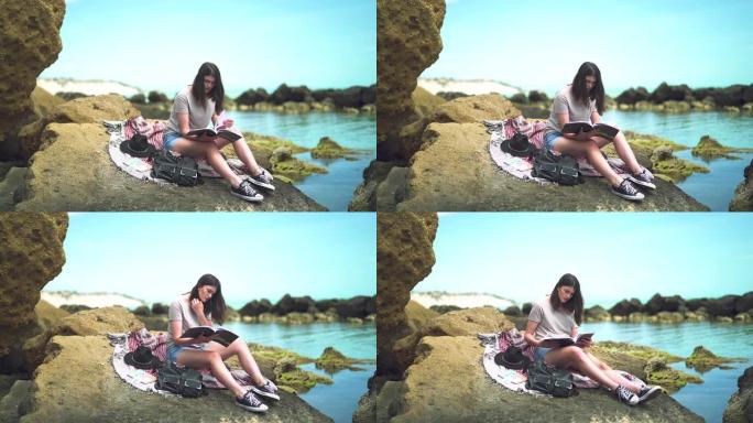 坐在沙滩上看书的女孩