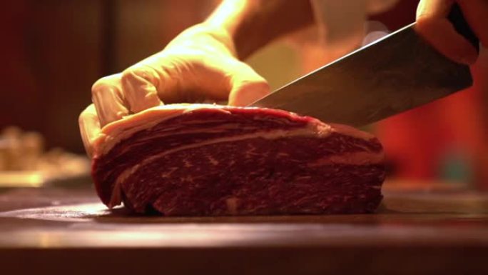 用手套将生肉牛肉切在菜板上的人手用刀切准确技巧