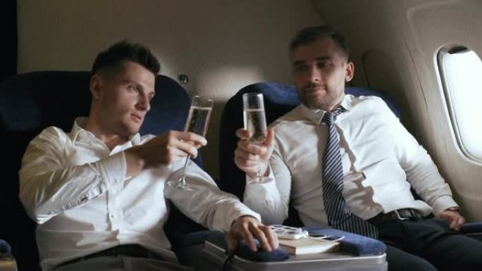 商业伙伴在飞机上喝香槟