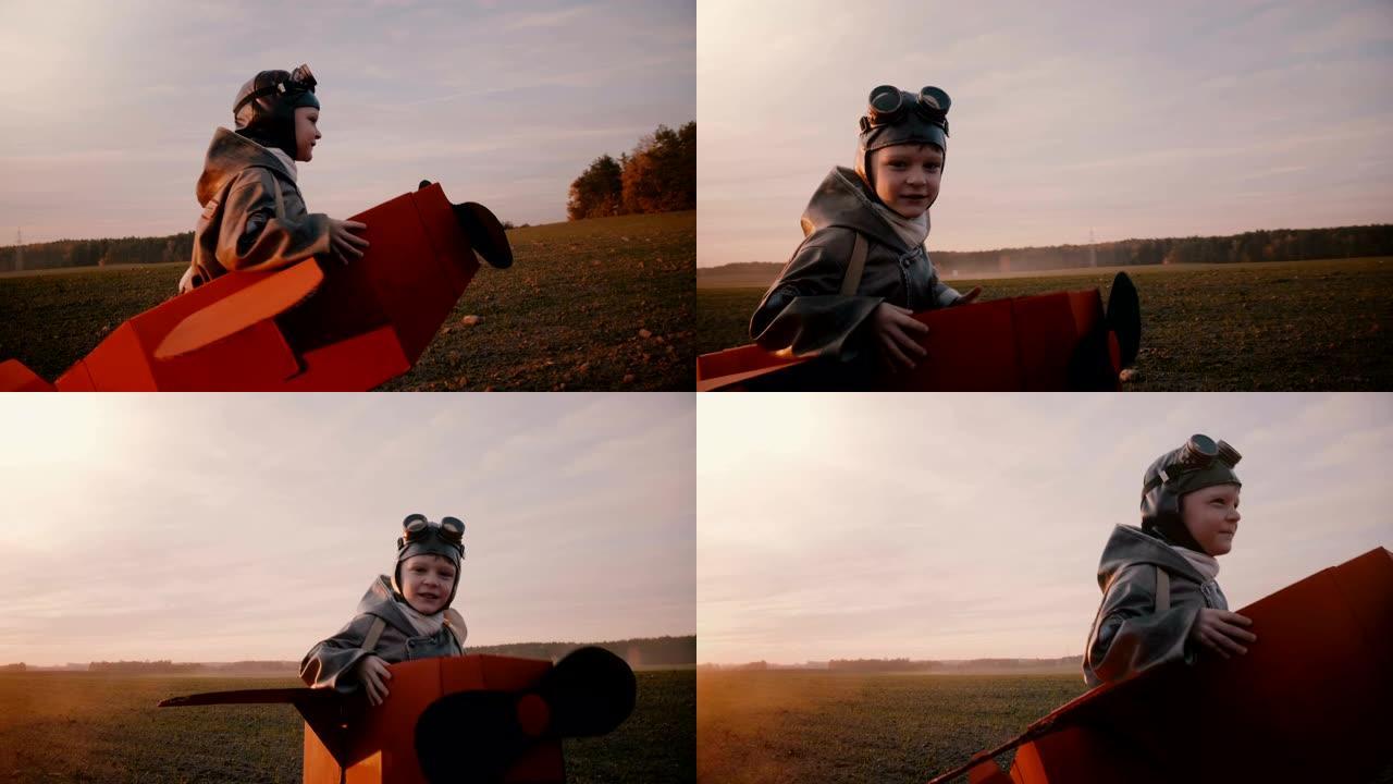 快乐兴奋的小飞行员男孩穿着有趣的纸板飞机服装，在美丽的日落慢动作中沿着田野奔跑。