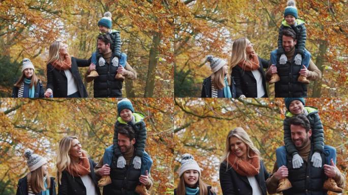 微笑的家庭沿着秋天的乡村小径行走，父亲将儿子扛在肩上