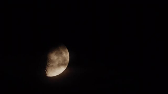 半个月亮在黑色的夜空中移动
