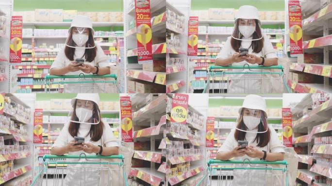 新型冠状病毒肺炎效果: 戴着保护面具的亚洲妇女在超市里用杂货店推车走路