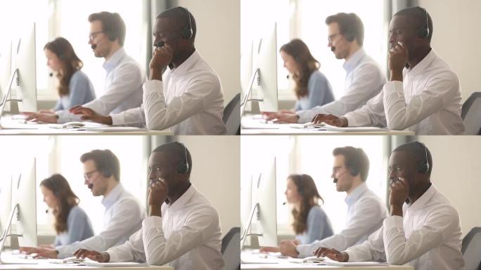 非洲男性呼叫中心工作人员戴着耳机远程帮助客户