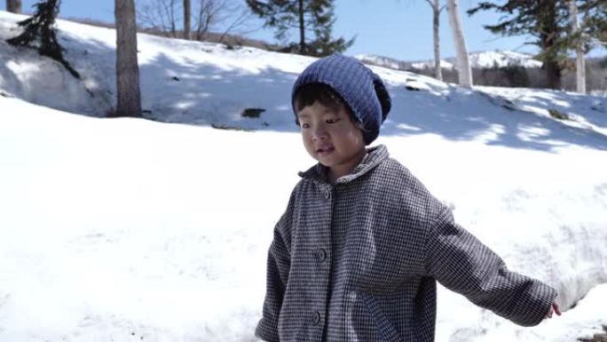 学龄前男孩在雪地里行走