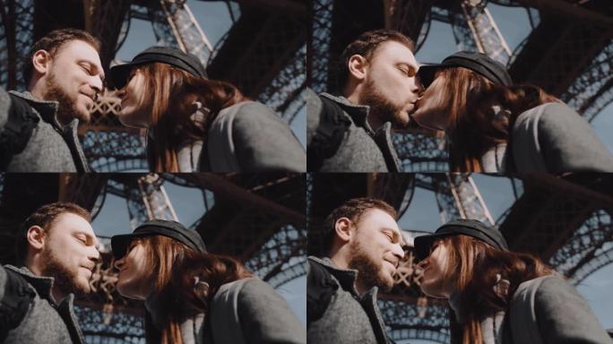 特写低角度快乐微笑浪漫情侣接吻，在巴黎埃菲尔铁塔下相视慢动作。