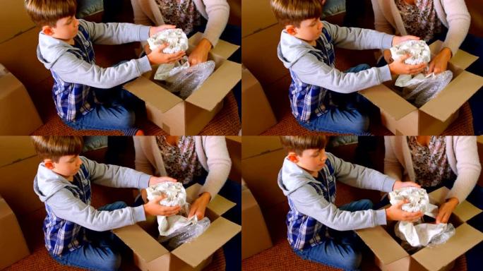 高加索儿子帮助母亲在家中打包物品的高角度视图4k