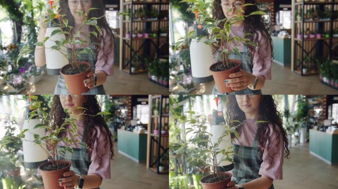 年轻女子花店在花店用水喷洒盆栽植物