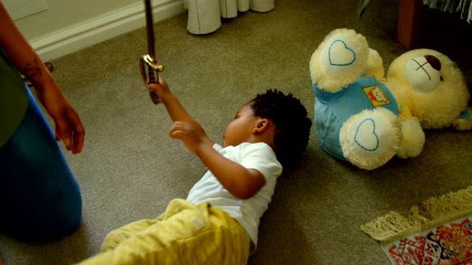 可爱的小黑男孩在舒适的家庭4k地板上玩耍和躺着的高角度视图