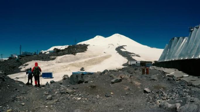 阳光普照在露营地的Elbrus斜坡上方。去远足