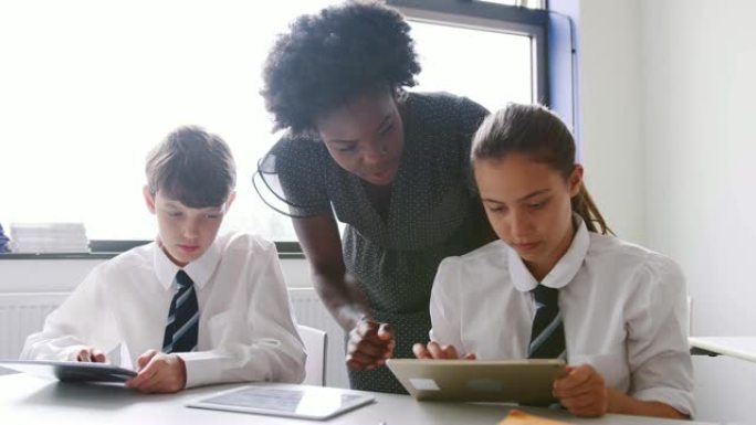 高中女教师在餐桌上，学生穿着制服，使用数码平板电脑上课