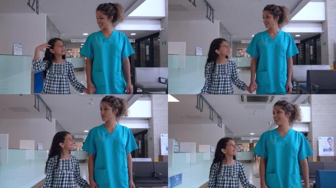 快乐护士与一个女孩在医院牵着手微笑着散步
