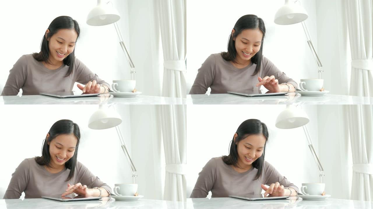 女人使用平板电脑，在放松时间在咖啡厅喝咖啡