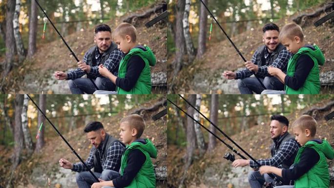 父亲和儿子在钓鱼，拿着鱼竿说话，男人在秋天的日子里教小男孩使用设备，周围有树木。家庭、爱好和休闲概念